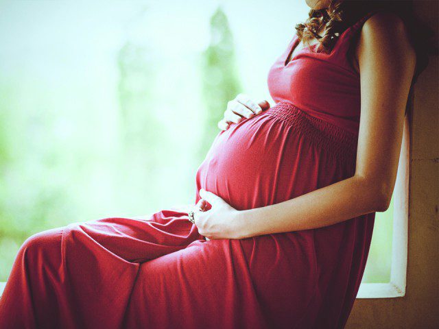 Pregnant women holding here belly